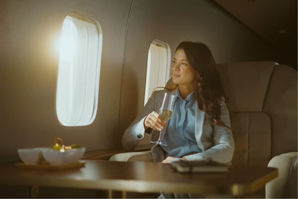 Woman enjoying champagne aboard a private jet